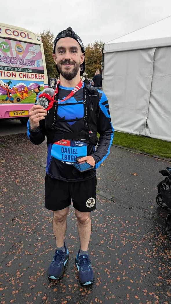 Daniel standing holding his medal from the Great Scottish Run 2024 in Glasgow Green